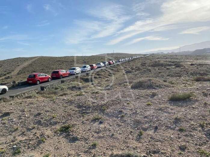 Imagen de la única vía de acceso al barrio llena de vehículos/TA.
